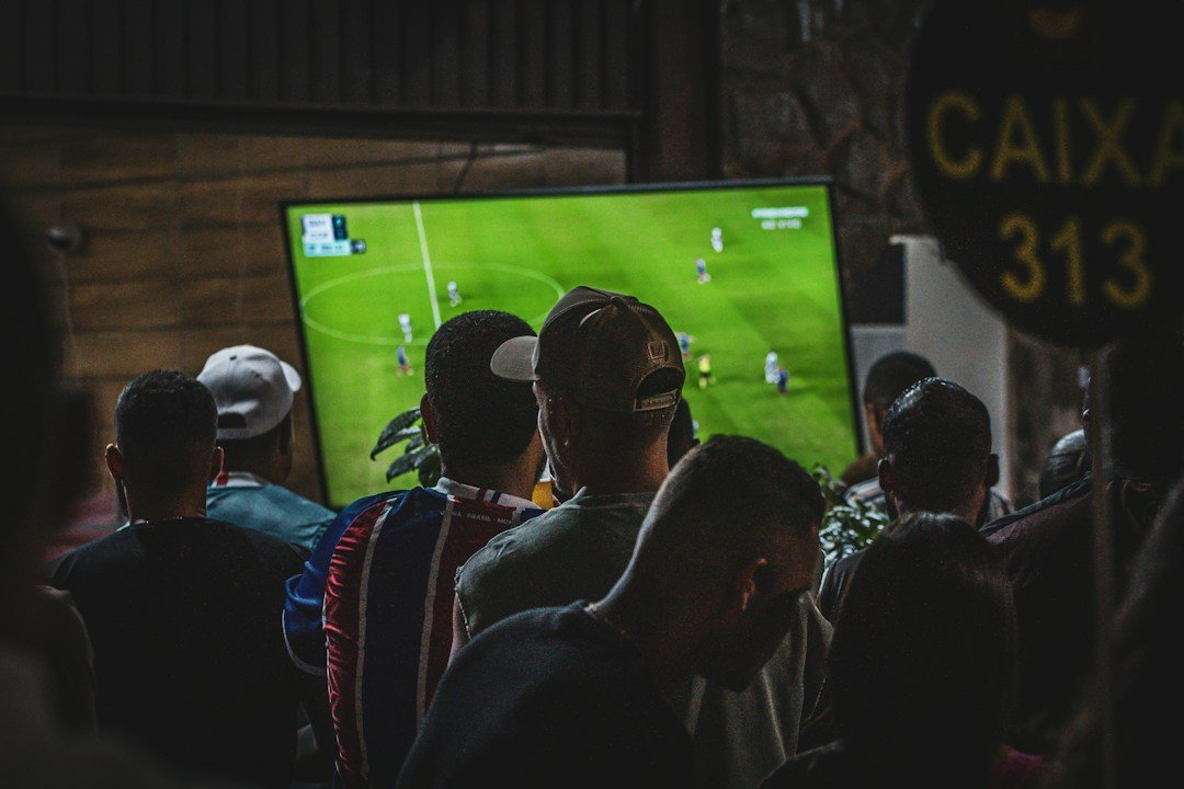 Friends watching a live football match on television